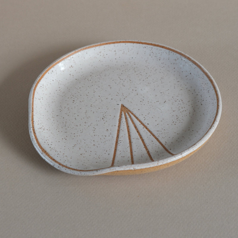 Ceramic dish with a brown triangle design on a beige background